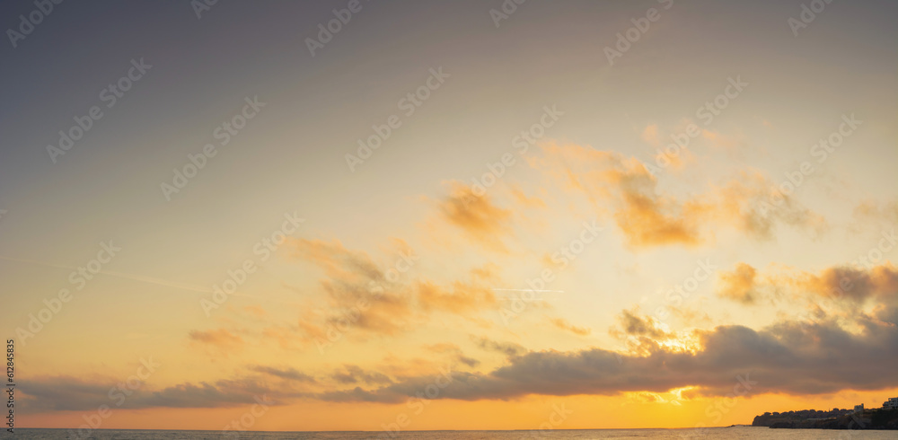 golden sunrise at the sea. fluffy clouds cover the sun above horizon. good weather forecast on summer vacation