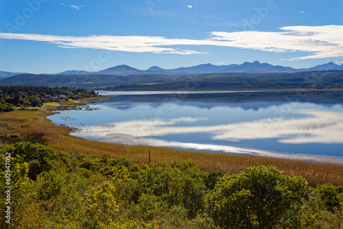 Late afternoon with cloud reflections over a large lake with reeds and waterfowl near Knysna, South Africa.