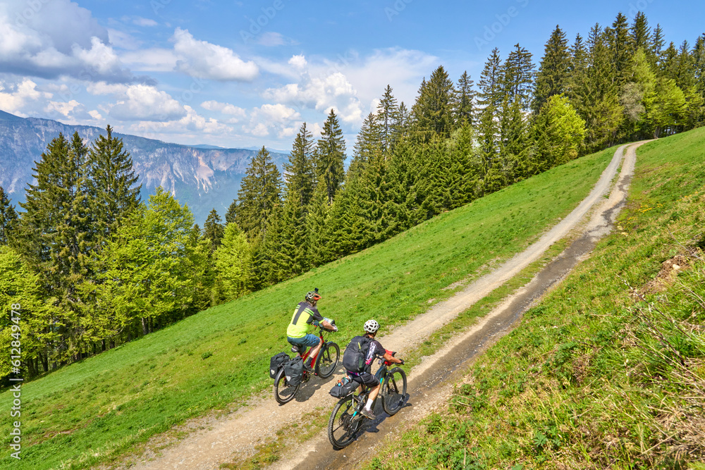 active senior couple on a mountain bike tour in the carinthian alps above Villach in Austria active senior couple on a mountain bike tour in the carinthian alps above Villach in Austria