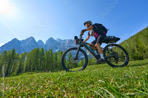 cheerful active senior woman on a E mountain bike tour at Vršič Pass in the Triglav National Park, Julian Alps above Kranska Gora in Slovenia