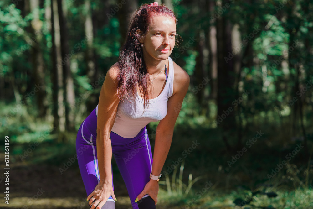 Young woman warming up before a fitness workout in a park near a trees.Healthy young woman warming up outdoors.woman runner warm up outdoor. Young woman warming up before a fitness workout in a park near a trees.Healthy young woman warming up outdoors.woman runner warm up outdoor.