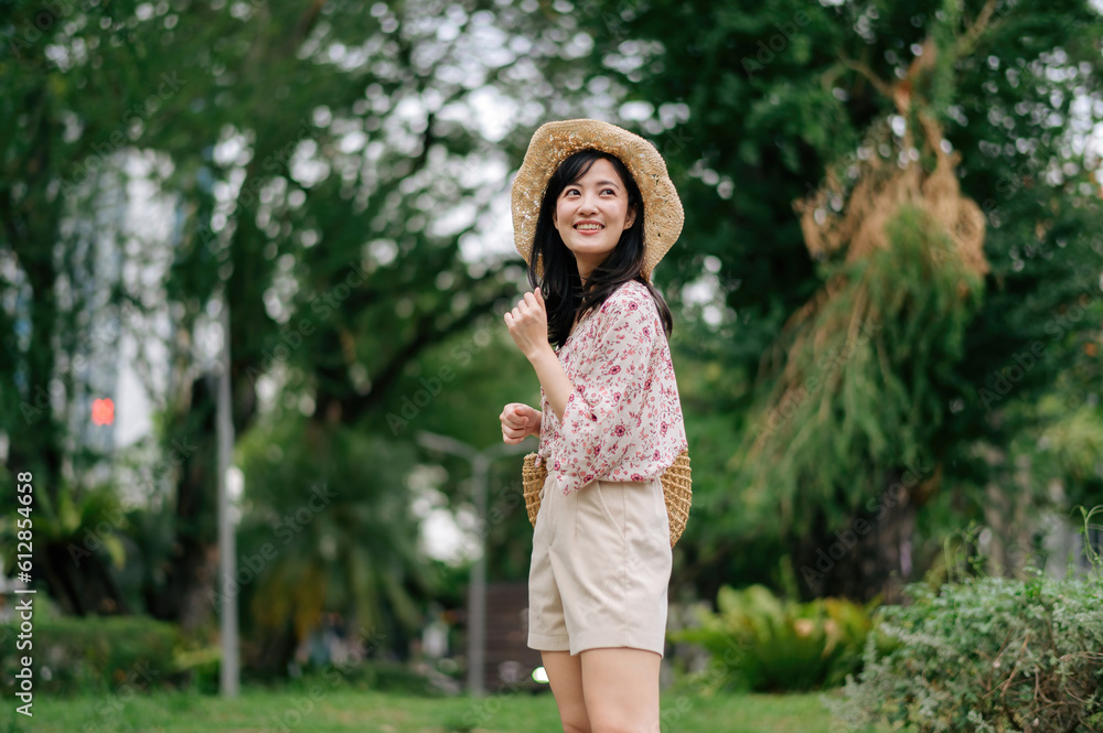 Portrait of asian young woman traveler with weaving hat and basket happy smile on green public park nature background. Journey trip lifestyle, world travel explorer or Asia summer tourism concept. Portrait of asian young woman traveler with weaving hat and basket happy smile on green public park nature background. Journey trip lifestyle, world travel explorer or Asia summer tourism concept.