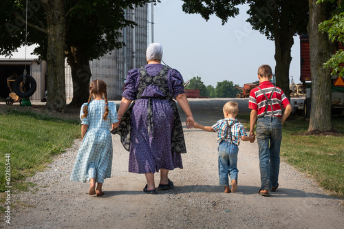 Amish Mother with children walking holding hands