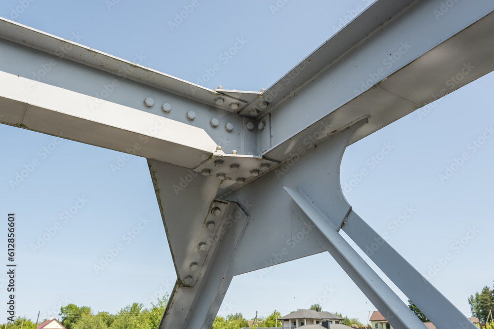 Obraz premium Bolts and nuts on metal plates of steel structure of heavy duty straight crossbar of frame and bridge support