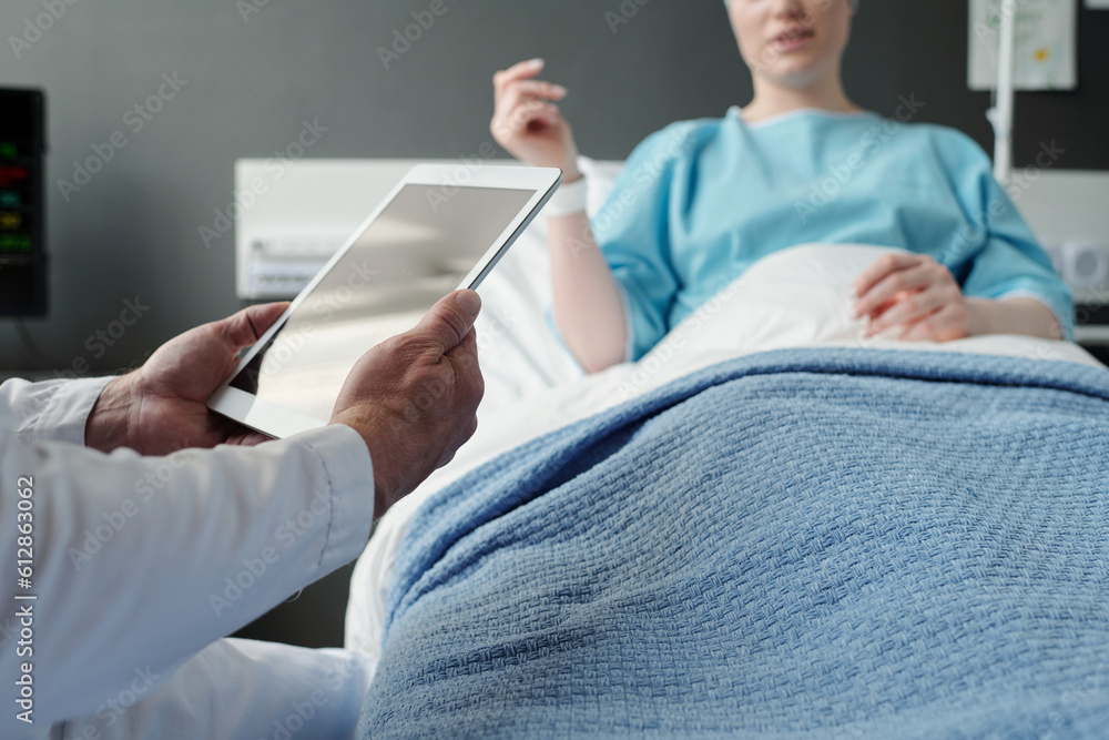 Selective focus on hands of experienced doctor using tablet during medical consultation and communication with female patient Selective focus on hands of experienced doctor using tablet during medical consultation and communication with female patient