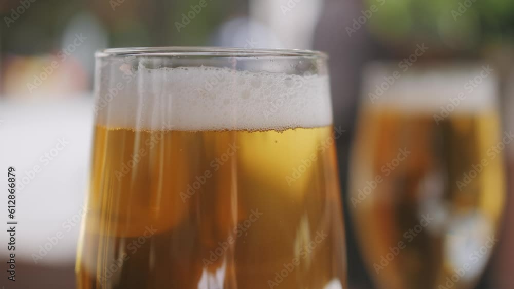 Celebration beer cheers concept - close up hands holding up glasses of beer of people group in outdoor party during their victory competition or successful task meeting vacation Celebration beer cheers concept - close up hands holding up glasses of beer of people group in outdoor party during their victory competition or successful task meeting vacation