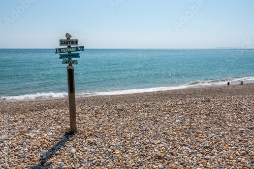 Caution Mermaid swimming area sign on beautiful deserted beach at Selsey West Sussex England photo