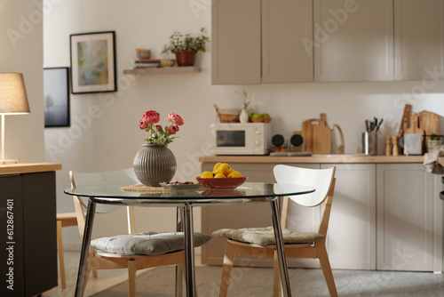 Wallpaper Mural Two chairs surrounding glass round table with bunch of red flowers in grey vase and plate of yellow pears in the center of spacious kitchen Torontodigital.ca