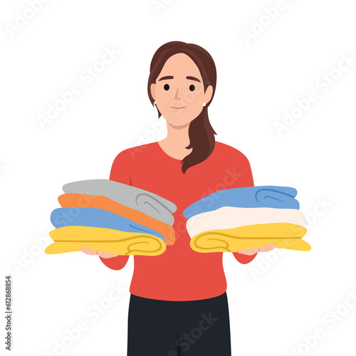 Young cartoon smiling woman standing and holding a stack of clothes. Flat vector illustration isolated on white background
