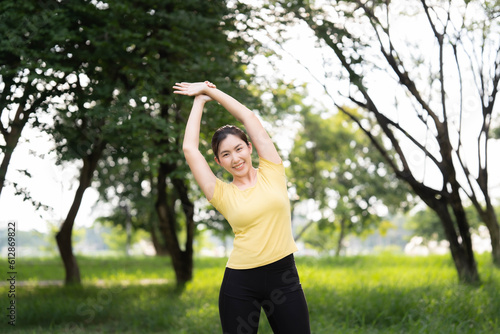 Asian woman stretching at the park before exercising. health care concept Stretching to warm up the muscles before going for a run.
