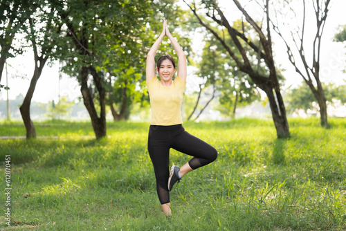 Asian woman doing yoga at the park.Fitness and wellness concept.