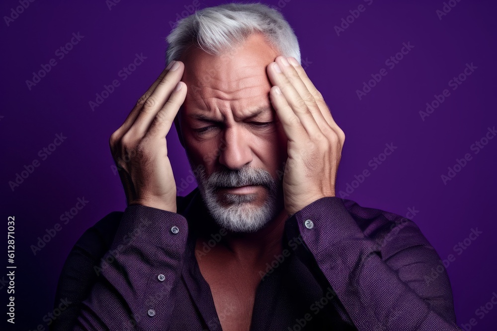 Close-up portrait photography of a glad mature man holding the hand on the forehead in a headache gesture against a deep purple background. With generative AI technology Close-up portrait photography of a glad mature man holding the hand on the forehead in a headache gesture against a deep purple background. With generative AI technology