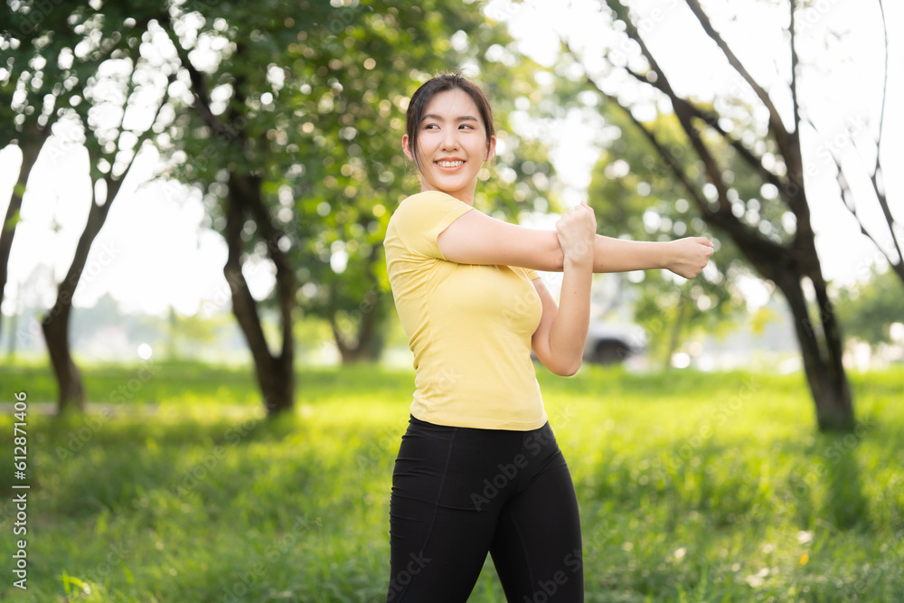 Asian woman stretching at the park before exercising. health care concept Stretching to warm up the muscles before going for a run. Asian woman stretching at the park before exercising. health care concept Stretching to warm up the muscles before going for a run.