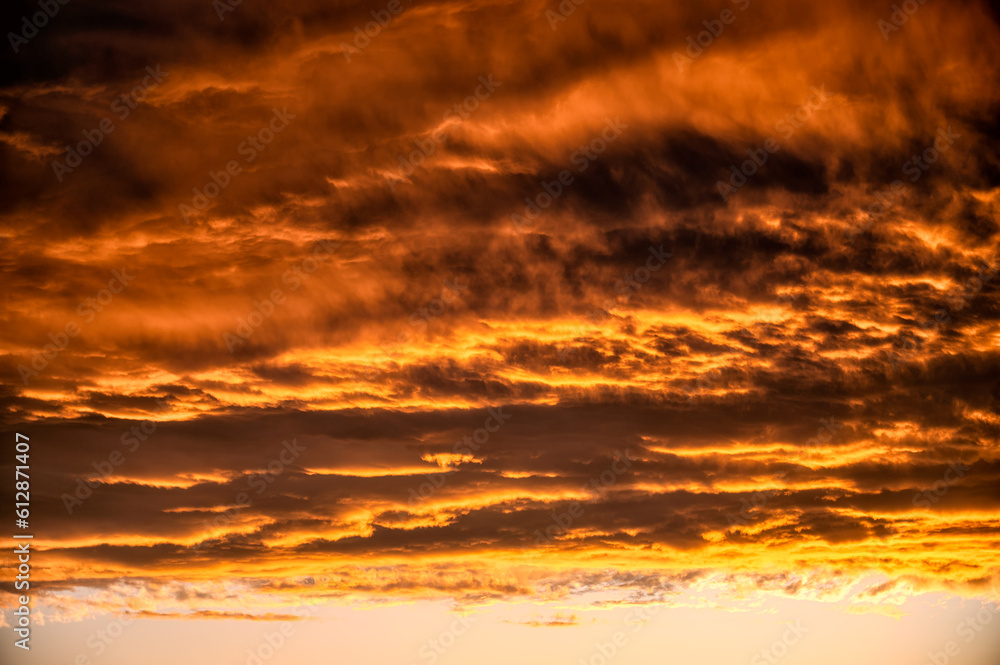 warm golden hour sky with bright orange yellow clouds. Ideal for sky replacement in modern photo editing software tools, beautiful evening atmosphere