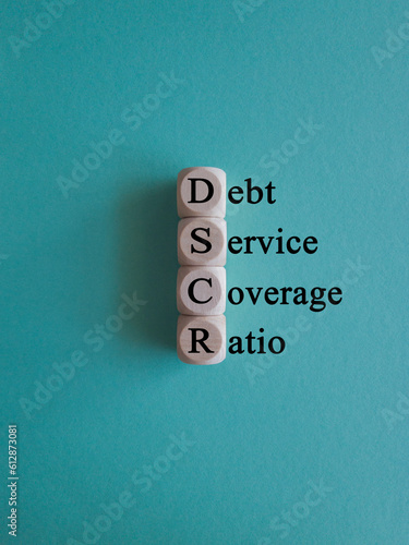 DSCR debt service coverage ratio symbol. Concept words DSCR debt service coverage ratio on wooden cubes on beautiful blue background. Business DSCR debt service coverage ratio concept. Copy space.