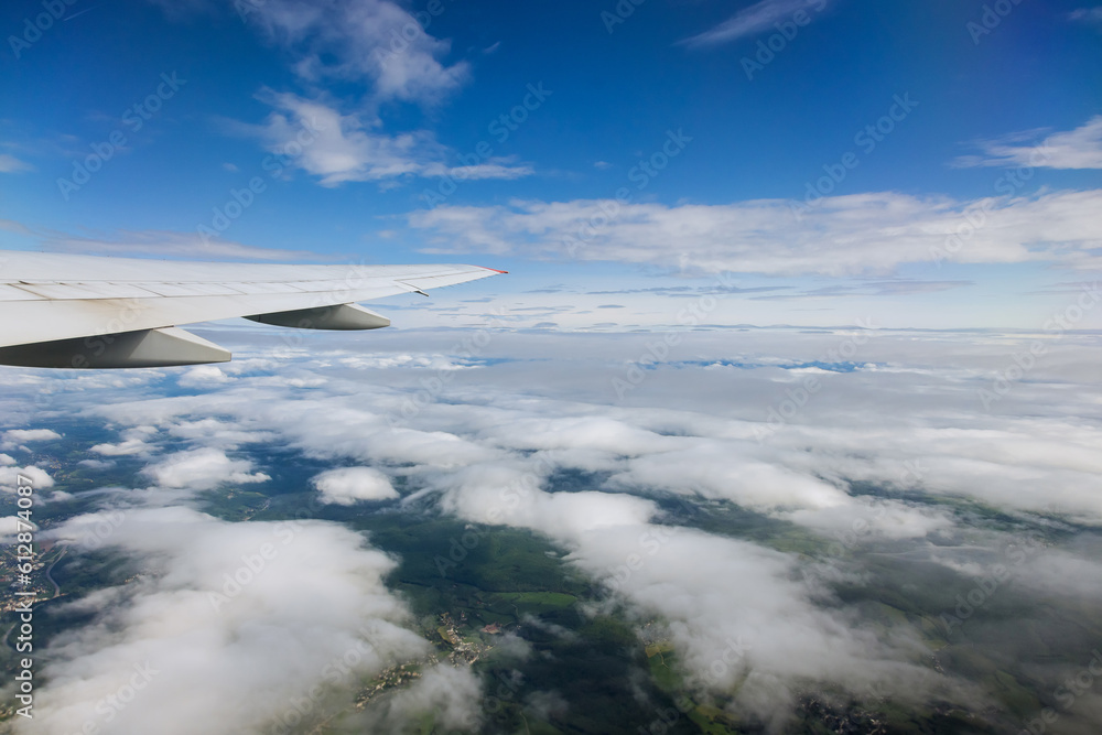 From window of flying plane airplane wing glides gracefully over Earth majestic landscapes vastness sea cloudy sky. From window of flying plane airplane wing glides gracefully over Earth majestic landscapes vastness sea cloudy sky.