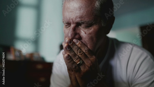 Fotografie Preoccupied older man covering face in shame and anxiety