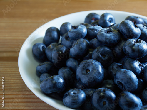 Freshly picked blueberries in a white vintage ceramic bowl. Selective focus, Free text space.