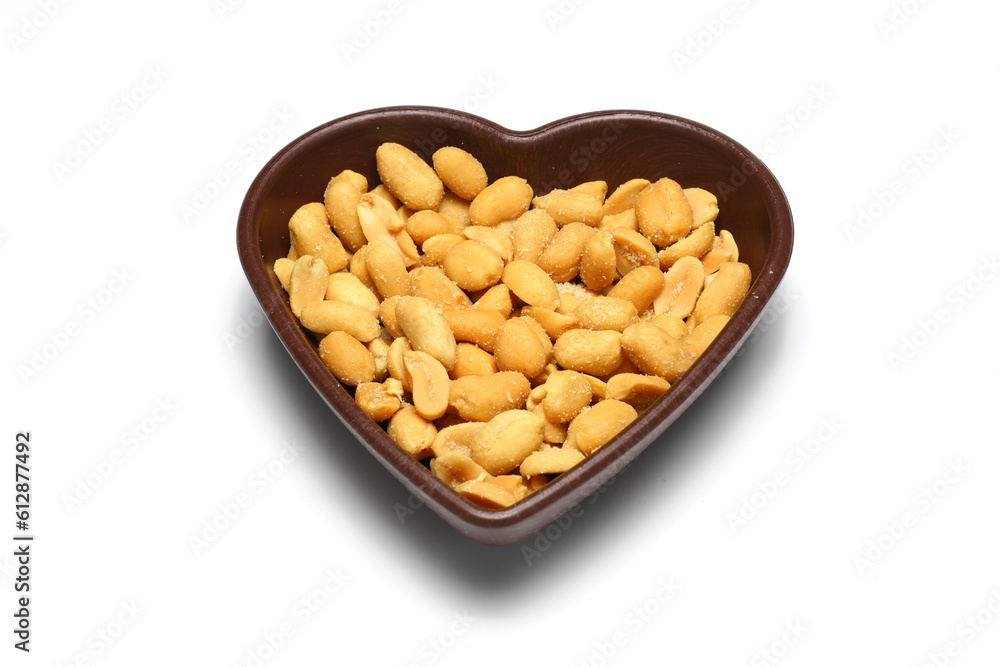 White heart shaped bowl with dried fruit mix (peanuts, walnuts, hazelnuts), isolated on white background. White heart shaped bowl with dried fruit mix (peanuts, walnuts, hazelnuts), isolated on white background.