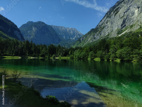 Bluntausee, Salzburger land, Austria. Mountain lake. Alps. Blue crystal clear water. Summer rocky landscape. Hiking place. Green landscape. Trees. Lake coastline.