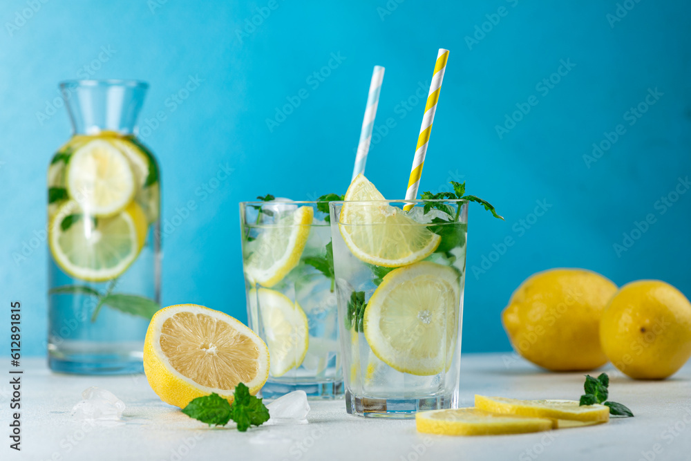 Fototapeta premium Lemonade with lemon slices, ice and mint leaves