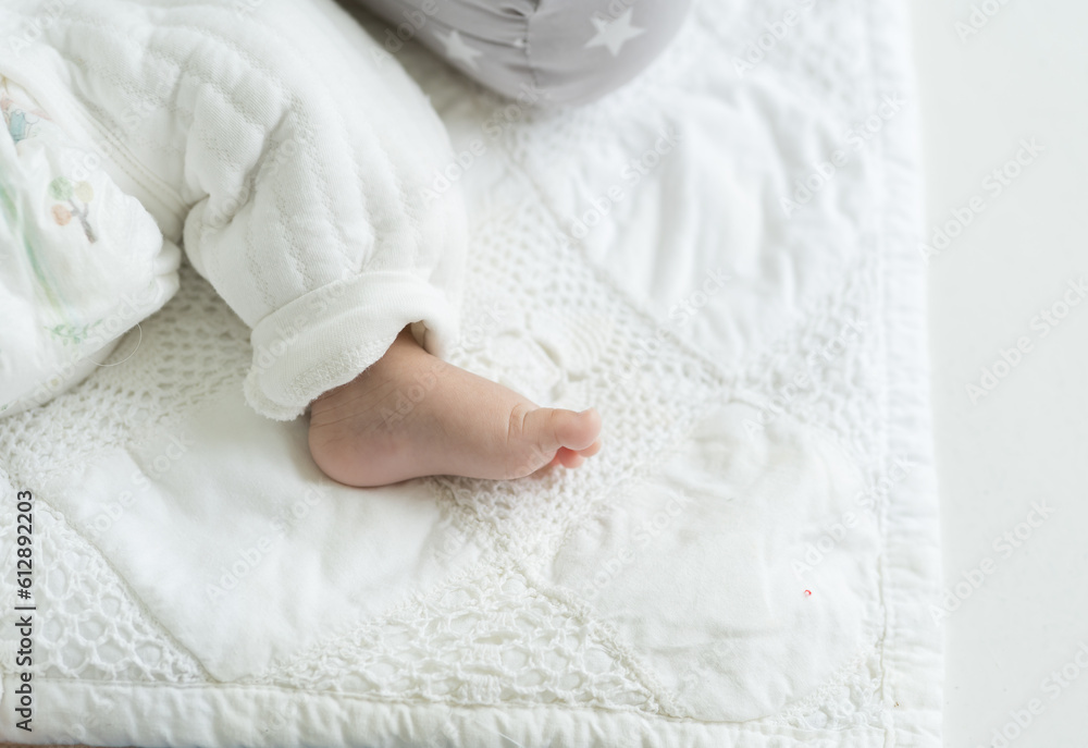 Top view of tiny foot of newborn baby during sleeping on blanket. Newborn baby foot. Asian newborn baby foot Top view of tiny foot of newborn baby during sleeping on blanket. Newborn baby foot. Asian newborn baby foot