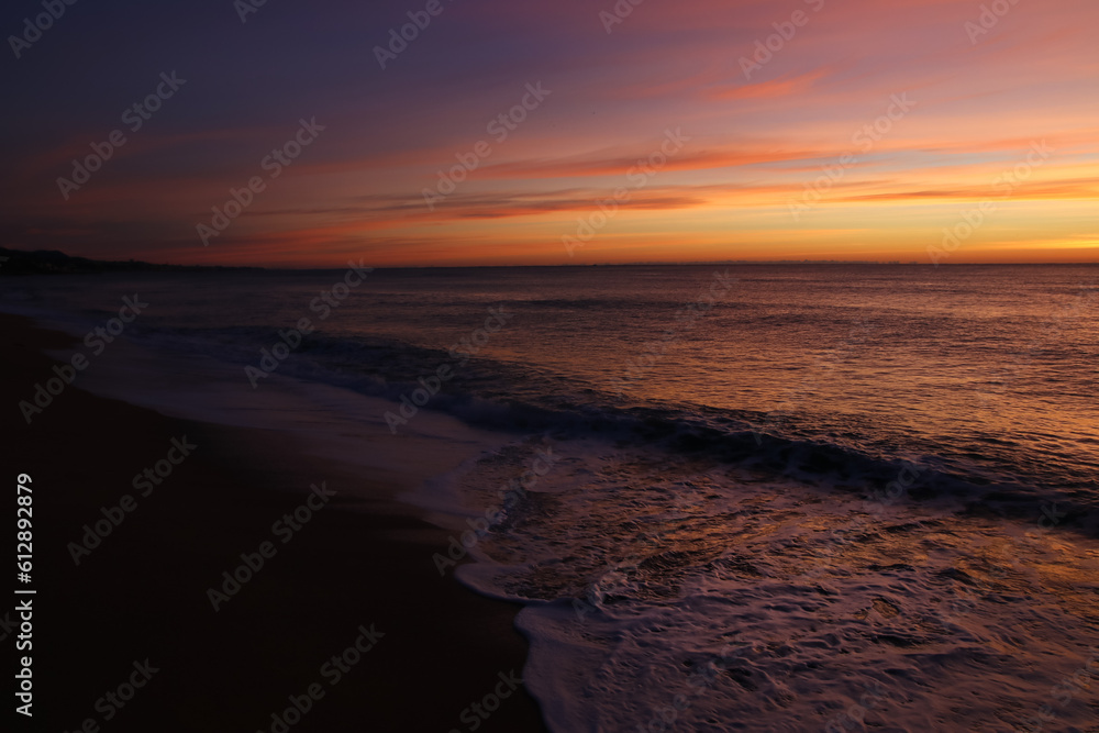 Precioso amanecer en el mar con tonos lilas y espuma de mar