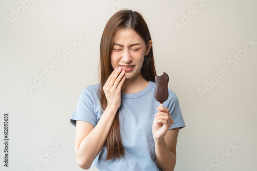 Fotografie Face expression suffering from sensitive teeth, Asian young woman touching cheek