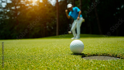 Golfer action to win after long putting golf ball in to the hole.