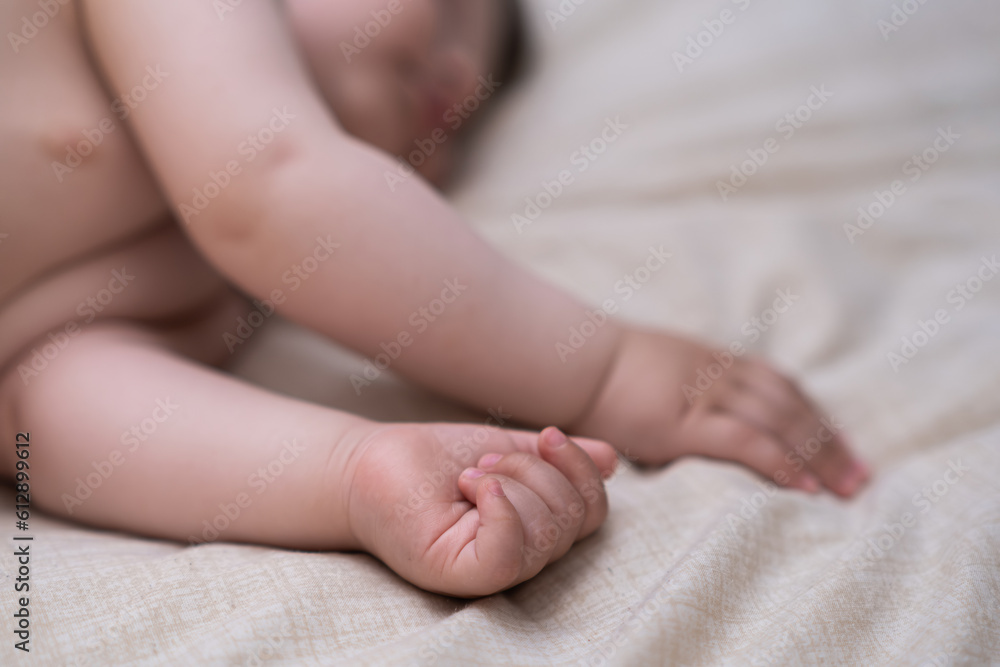Innocent little boy sleeping in crib grabbing soft white sheet with tiny hands adorable infant baby enjoying relaxing in cozy nursery after breastfeeding in morning closeup Innocent little boy sleeping in crib grabbing soft white sheet with tiny hands adorable infant baby enjoying relaxing in cozy nursery after breastfeeding in morning closeup
