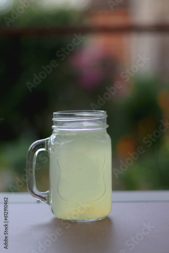 Glass of lemonade served in the garden. Selective focus.
