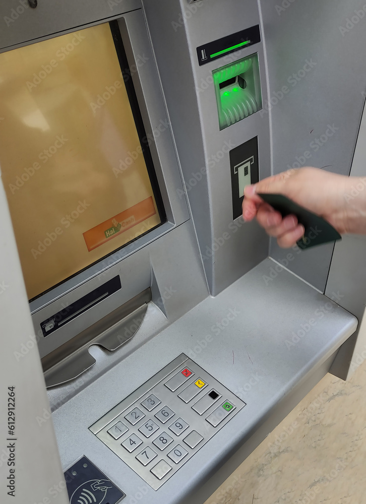 A hand has inserted the cretito card into the ATM machine.