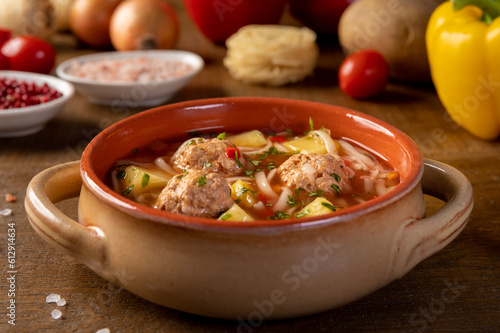 Meatballs soup, romanian traditional food. wooden background. Ciorba de perisoare. photo