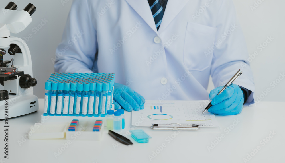 Close up view of scientist analyzing a liquid in the test tubes in laboratory. Close up view of scientist analyzing a liquid in the test tubes in laboratory.