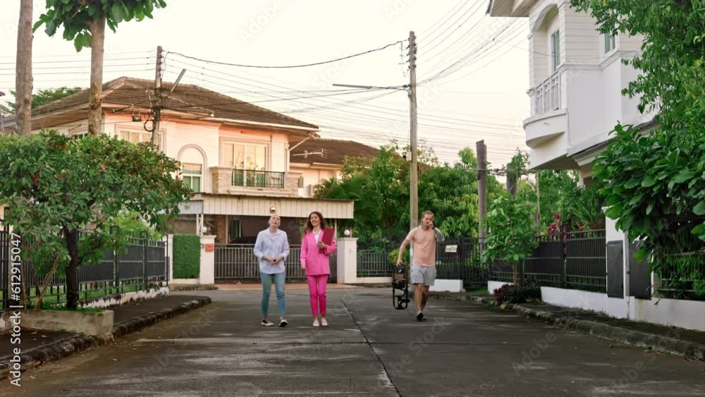 After the professional cameraman finished shooting the story, the realtor and her client continue their journey through the exclusive village, walking between houses and exchanging dialogue. After the professional cameraman finished shooting the story, the realtor and her client continue their journey through the exclusive village, walking between houses and exchanging dialogue.