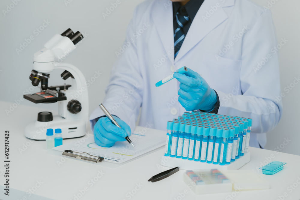 Close up view of scientist analyzing a liquid in the test tubes in laboratory. Close up view of scientist analyzing a liquid in the test tubes in laboratory.