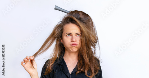 Bilde på lerret Sad woman combing styling tangled dry  weak hair on a white background