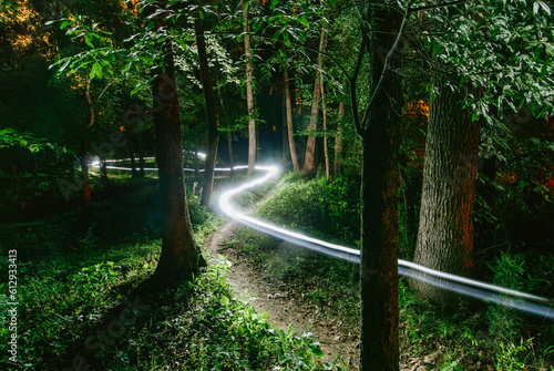 The streaks of a rider's headlamp make a winding trail through the woods in a long exposure during a mountain bike race in Conyers, Georgia.