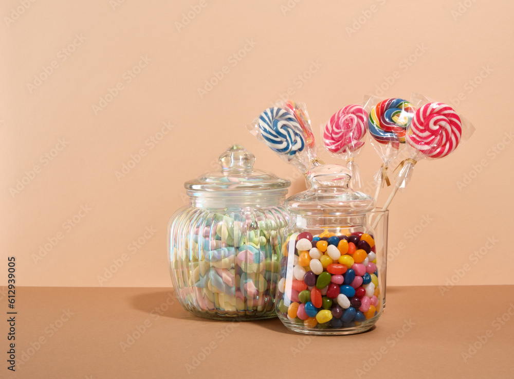 Sweet composition. Candy, marshmallows and lollipops collection on a beige background. Copy space for text.