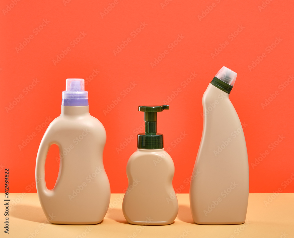 Two beige colored bottles of laundry detergent and a dispenser of pleasant smelling liquid soap on the table. Two beige colored bottles of laundry detergent and a dispenser of pleasant smelling liquid soap on the table.