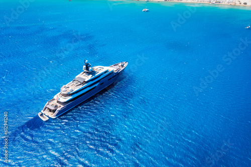 Fototapeta Naklejka Na Ścianę i Meble -  A drone view of a luxury yacht in the middle of the sea. Vacation and holidays. Summer time for sea travel. The sea bay. Photo for background and wallpaper. Mediterranean Sea.