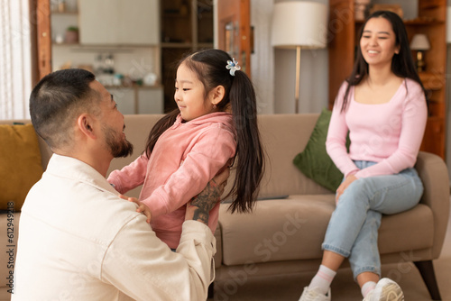 Billede på lærred Japanese Woman Looking At Husband Hugging Their Little Daughter Indoor