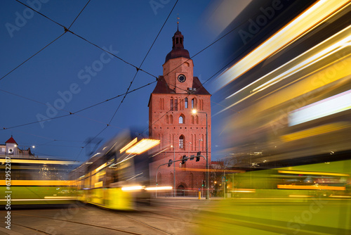 Gorzów Wielkopolski nocą - katolicka gotycka katedra Maryi Panny, ceglany gotyk, tramwaj, ruch uliczny