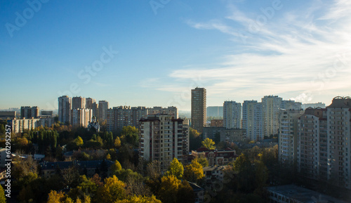 Panoramic urban landscape - multi-storey modern houses of Reutov in the Moscow region among the lush foliage of trees on a clear autumn morning and a space for copying