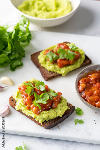 Avocado toast with mashed avocado and baked beans topping, healthy vegan protein and healthy fats packed snack or lunch