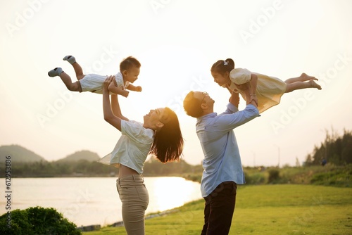 Portrait of happy family travel in park on weekend with sunset view, Father mother and children having activities outdoor playing together with happiness, Family lifestyle 