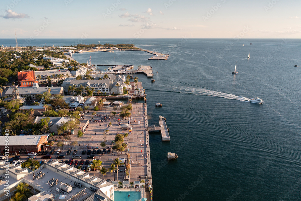 Aerial view of Mallory Square in downtown Key West, Florida along the harbor coast with boats and yachts during golden hour sunset in the Florida Keys