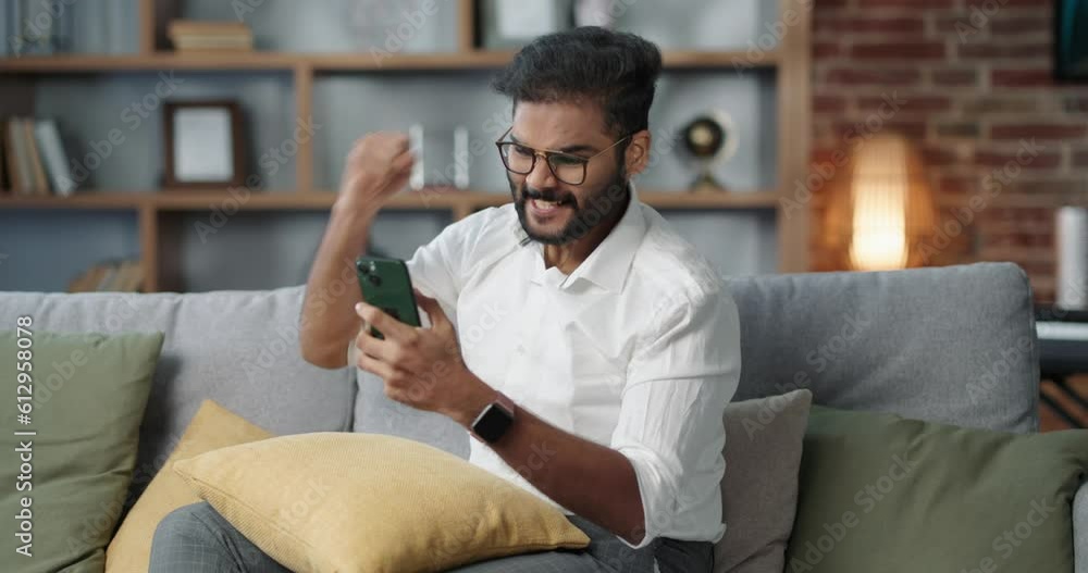 Zoom out of a corporate Indian man having a video call with the team. Zoom out of a corporate Indian man having a video call with the team.