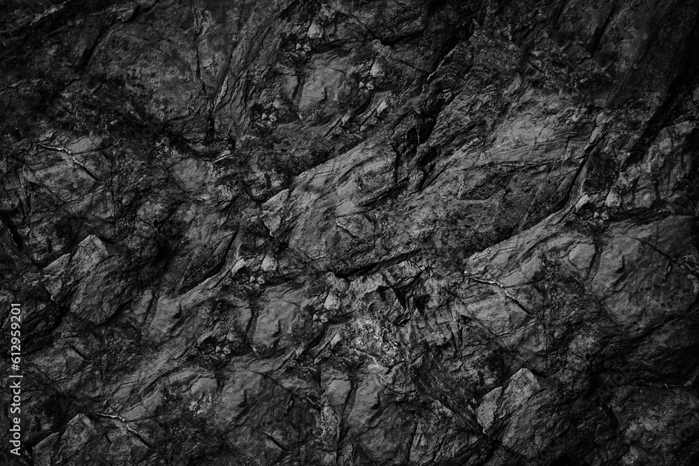 Black white rock texture. Dark gray stone granite background for design. Rough cracked mountain surface. Close-up. Crumbled.