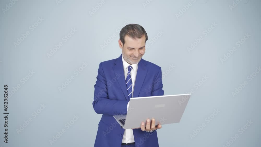 Satisfied businessman looks at laptop and approves. Satisfied businessman looks at laptop and approves.